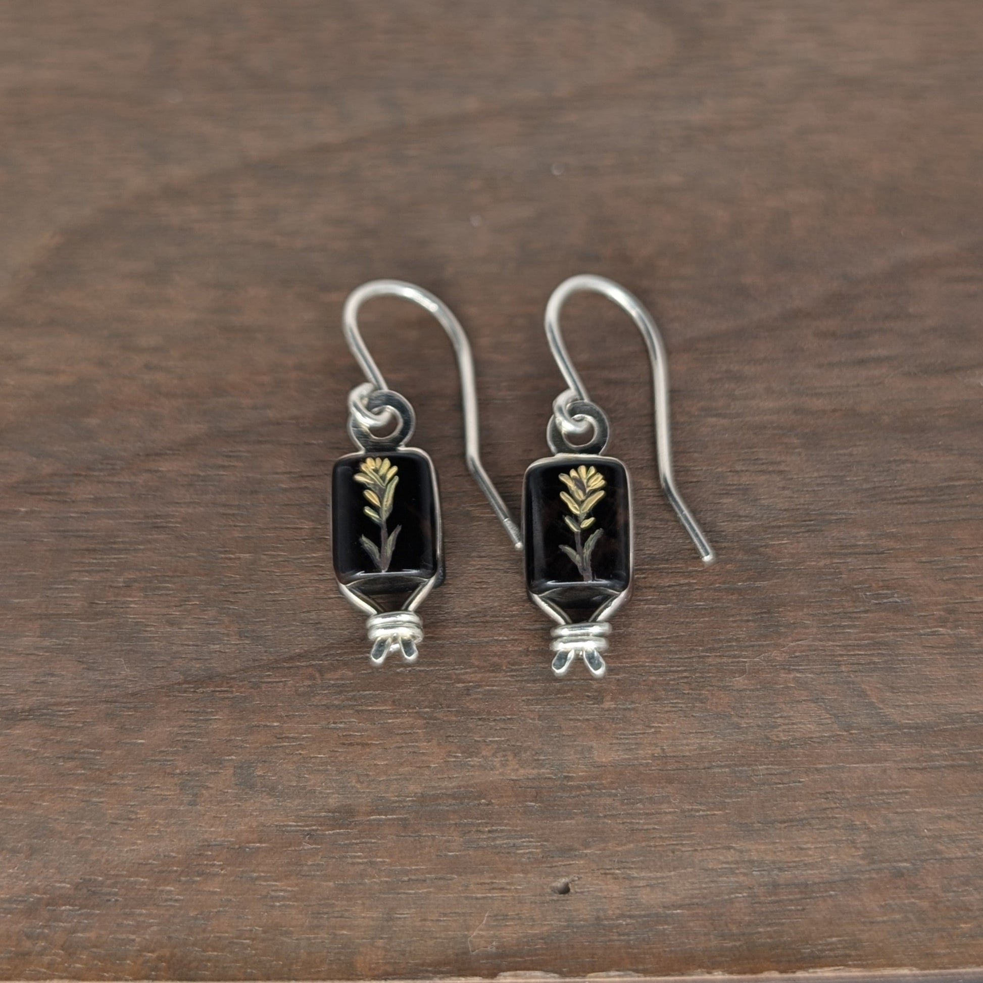Pair of silver earrings with hand oil painted image of yellow flower on utah obsidian